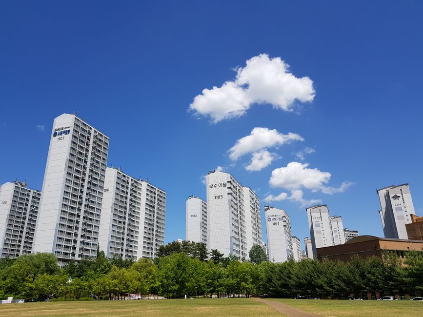 2026년 공공임대주택 단지의 전경. 현대적인 건물과 잘 가꾸어진 녹지 공간이 조화를 이루며 안정적이고 쾌적한 주거 환경을 보여줍니다.